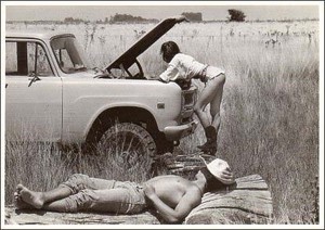 ポストカード モノクロ写真「昼寝をする男性と車の修理をする女性」